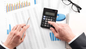 Businessman working with using a calculator to calculate the numbers. Finance accounting concept
